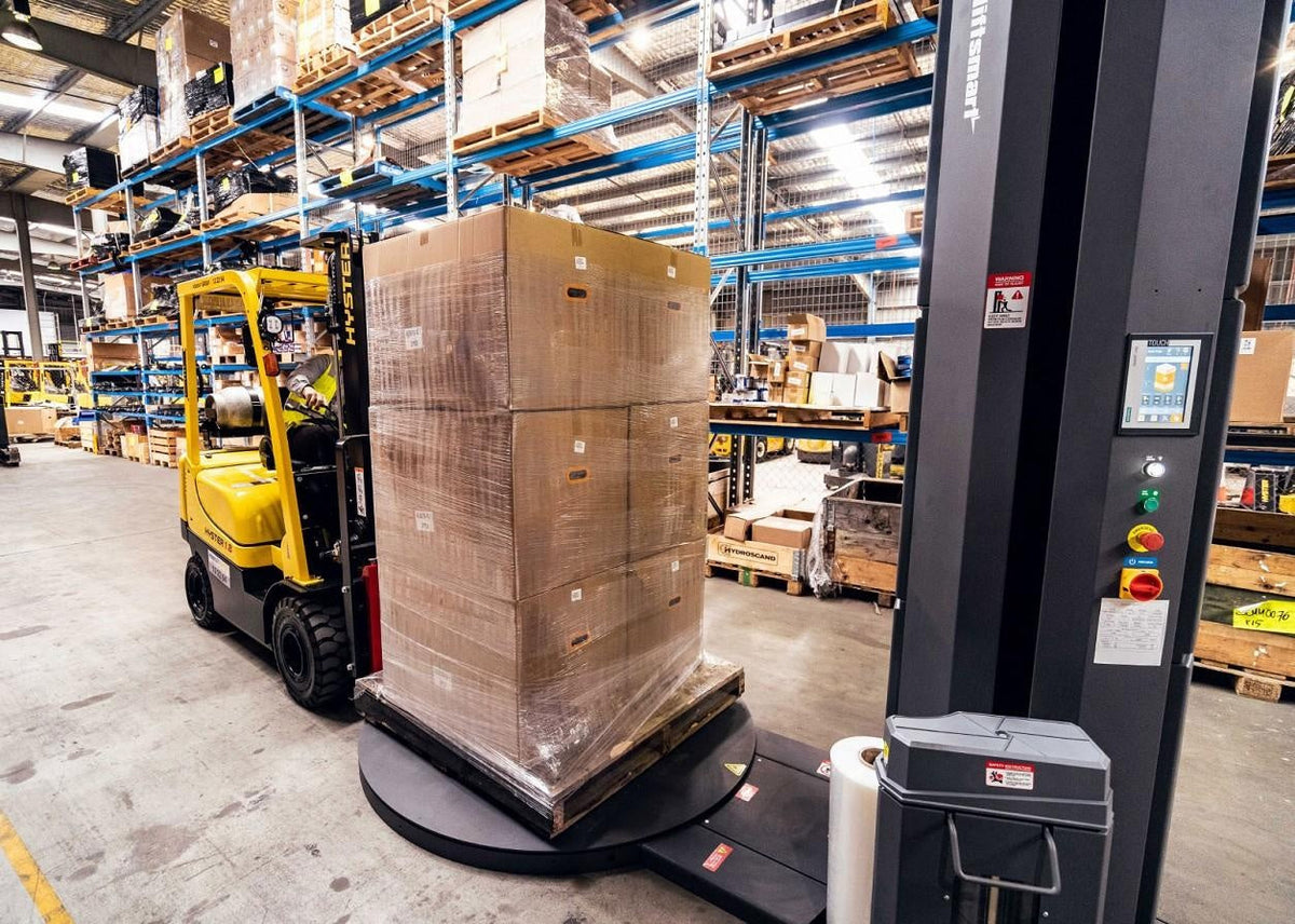 Automatic pallet wrapping machine securing warehouse load with stretch film